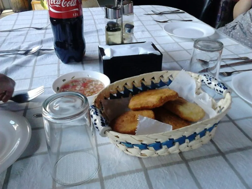 Salón restaurante de dos niveles con vigas de madera y comensales almorzando